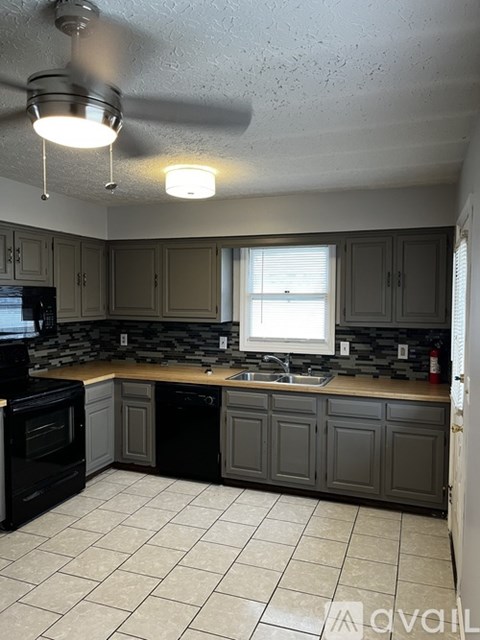 A kitchen with a black oven and cabinets.