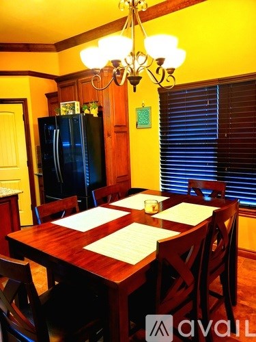 A dining room with a wooden table and chairs.