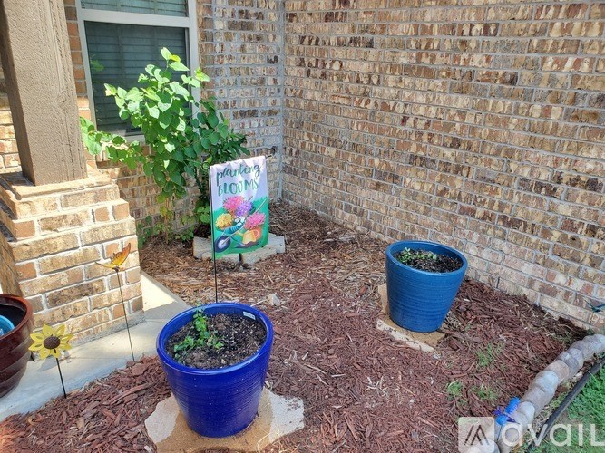 A small garden with a sign that says "Planter's HQ" and two pots of plants.