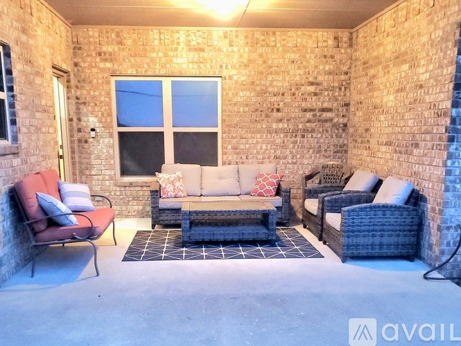 A patio with a brick wall and furniture.