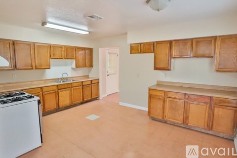A kitchen with wooden cabinets and a white stove.