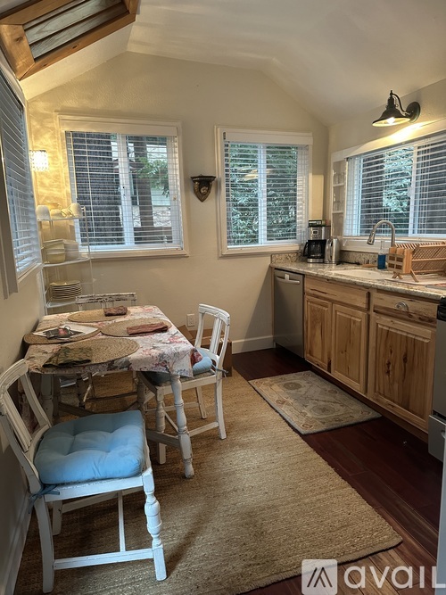 A kitchen with a table and chairs in the foreground and a sink in the background.