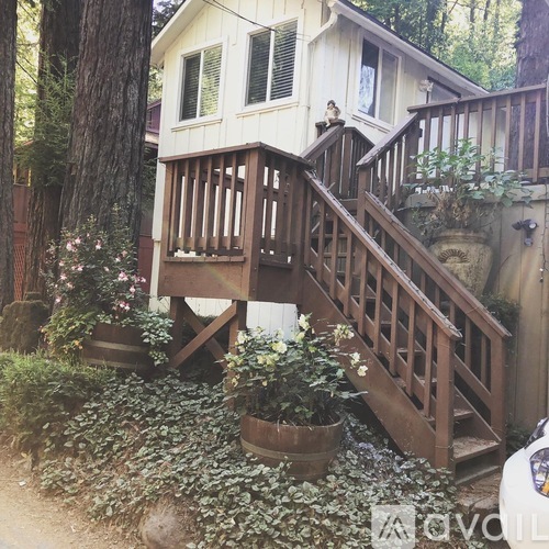 A small house with a wooden deck and stairs.