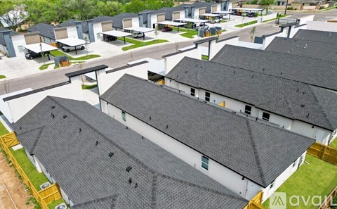 Two houses with grey roofs are in the foreground of the image.