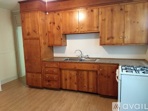 A kitchen with wooden cabinets and a white stove.