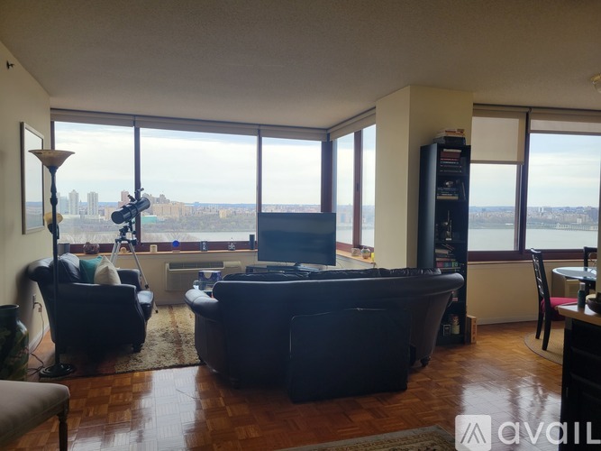 A living room with a large window overlooking a cityscape.