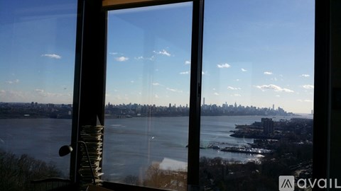 A view of a city skyline through a window with a reflection of the sky and buildings.