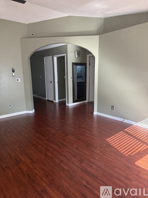 A room with wood flooring and a wall-mounted cabinet.