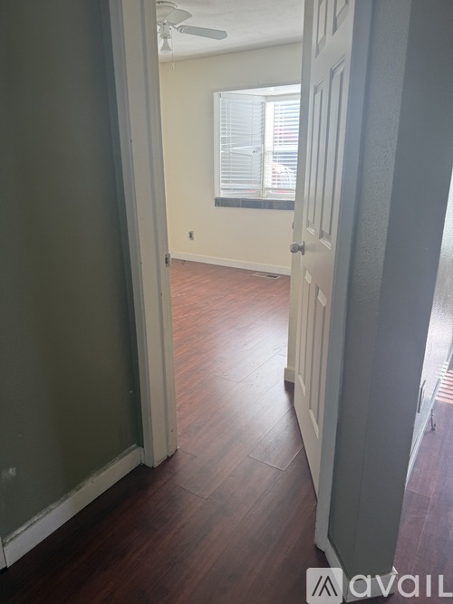 A hallway with wood floors and a white door.