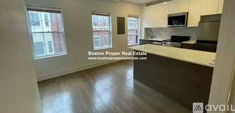 A kitchen with white cabinets and a black stove top oven.