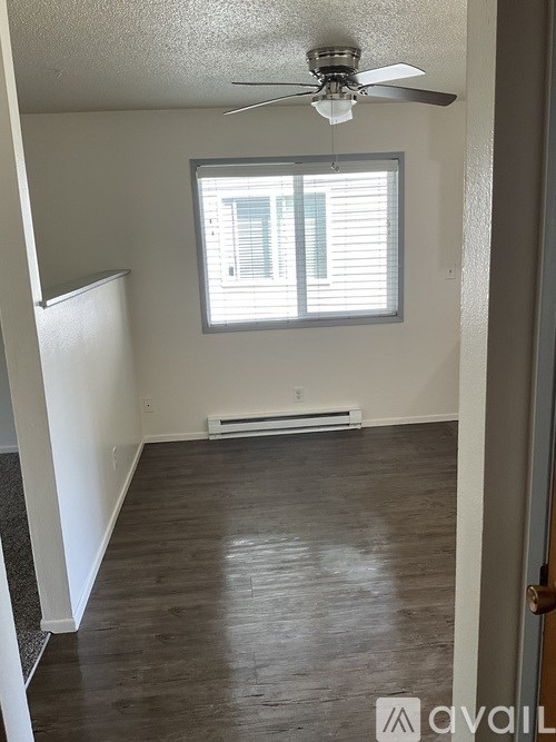 A room with a ceiling fan and a window.