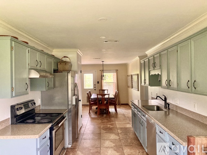 A kitchen with a dining table and chairs in the middle of the room.