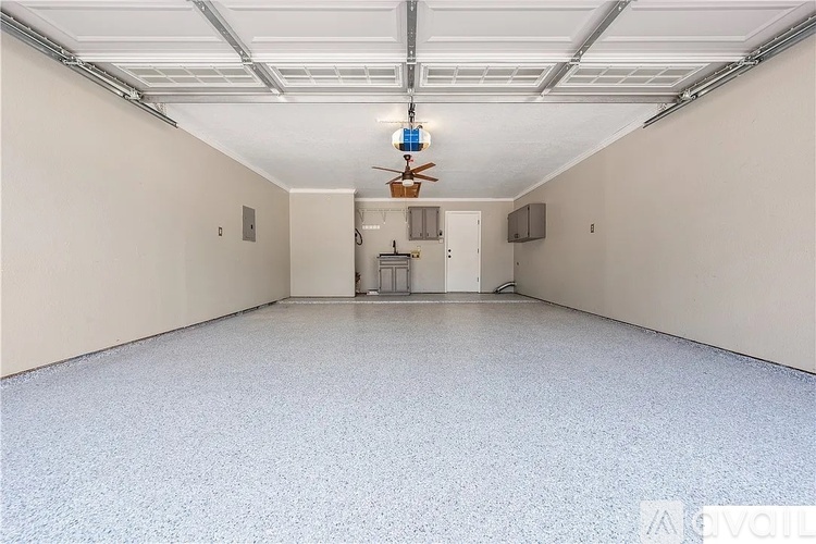 A spacious room with a ceiling fan and a light fixture.