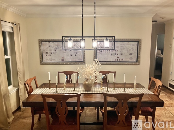 A dining room with a table set for six people.