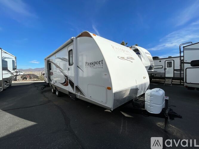 A white RV with the word "Passport" on it is parked in a lot.