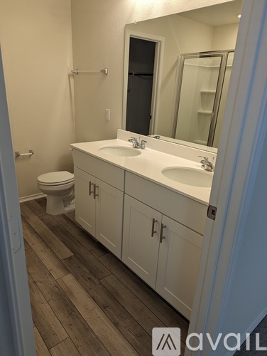 A bathroom with a toilet, sink, and mirror.