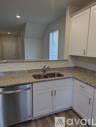 A kitchen with white cabinets and granite countertops.