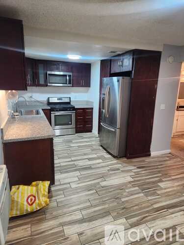 A kitchen with a refrigerator, microwave, oven, and stove.