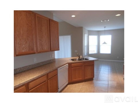 A kitchen with wooden cabinets and a white dishwasher.