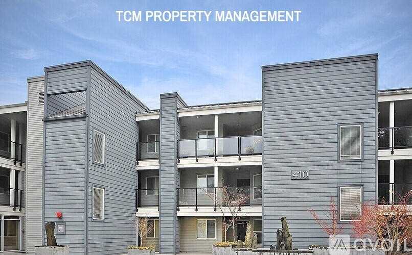 A modern apartment building with the text "TCM PROPERTY MANAGEMENT" on the top.