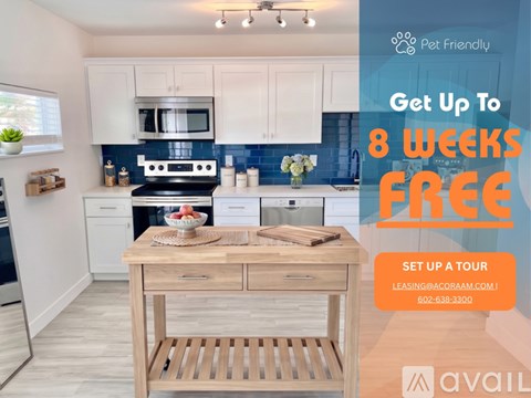 A kitchen with a refrigerator, sink, and cabinets is on display for a move-in special.