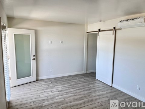 A room with a sliding door and a window with blinds.