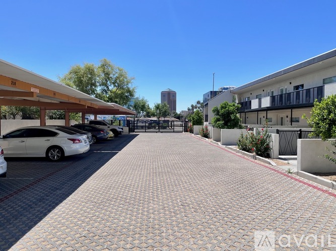 A parking lot with cars parked under awnings.