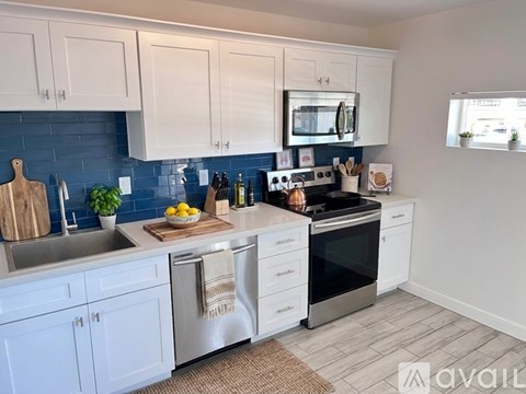 A kitchen sink with a chrome faucet and blue tiles.