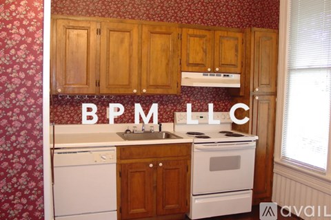 A kitchen with wooden cabinets and a white dishwasher.