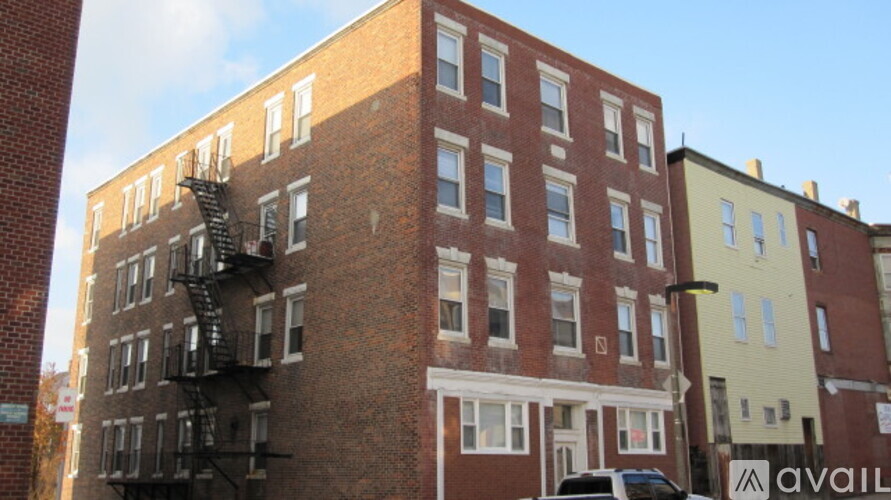 A tall brick building with a fire escape on the side.