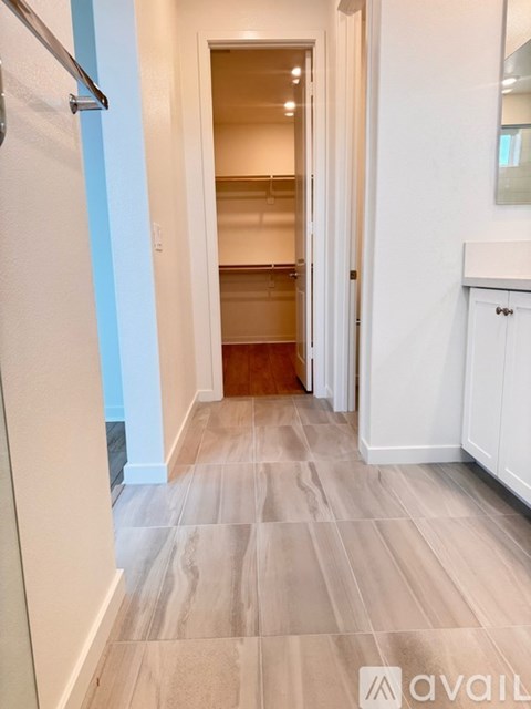 A kitchen with a white refrigerator and wooden flooring.