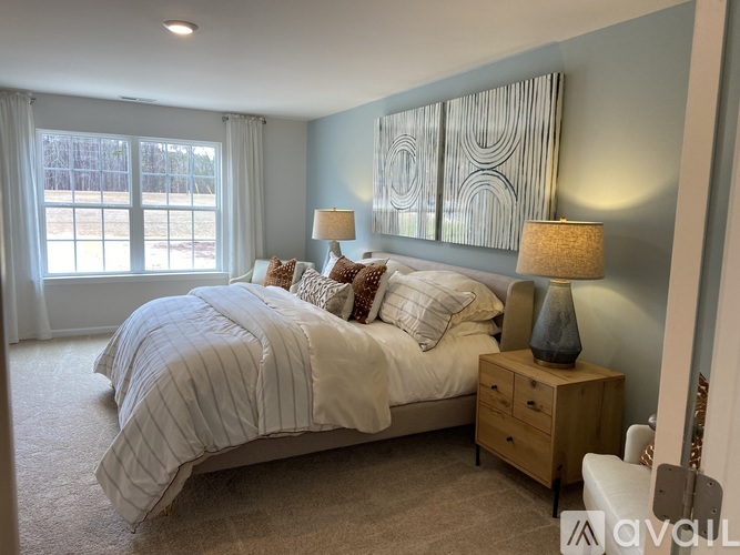 A bedroom with a large bed and a window with a view of trees.