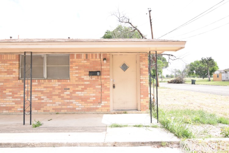 A small brick house with a white door and a small porch.