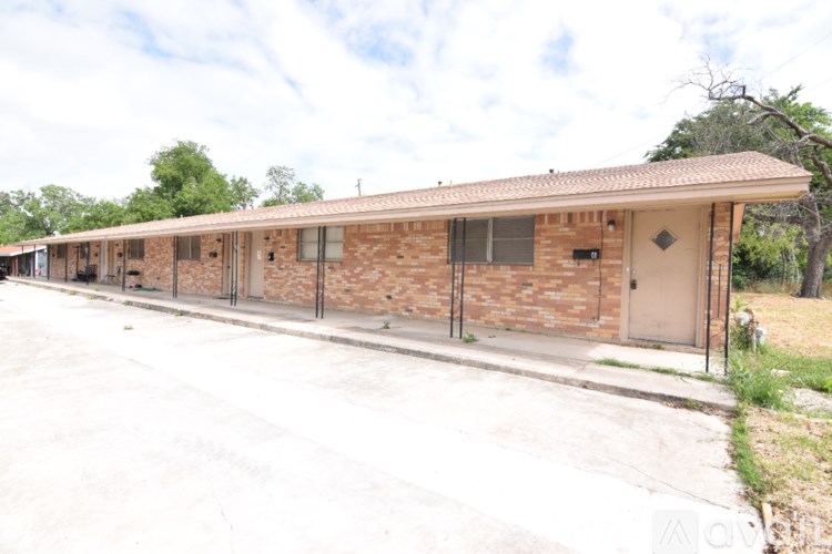 A row of houses with a white fence in front.