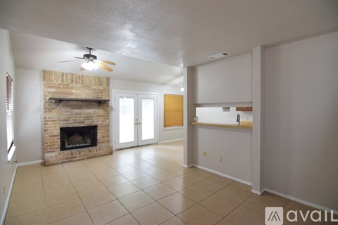 A kitchen with white appliances and cabinets in a room with beige carpeting.