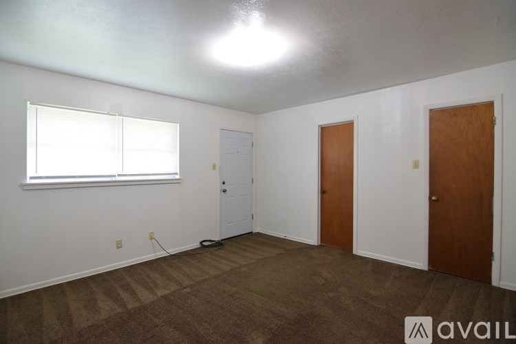 A house with a brown brick exterior and a brown roof with a white trim.
