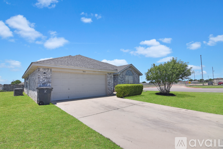 A house with a garage and a driveway in front.