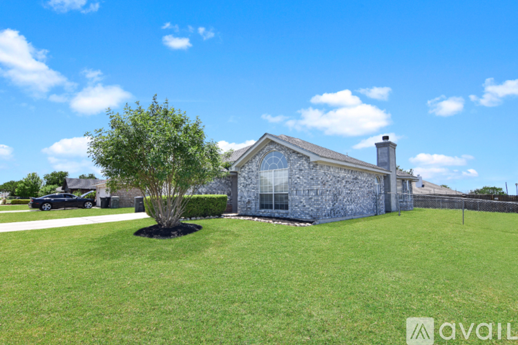 A house with a blue stone exterior and a large lawn.