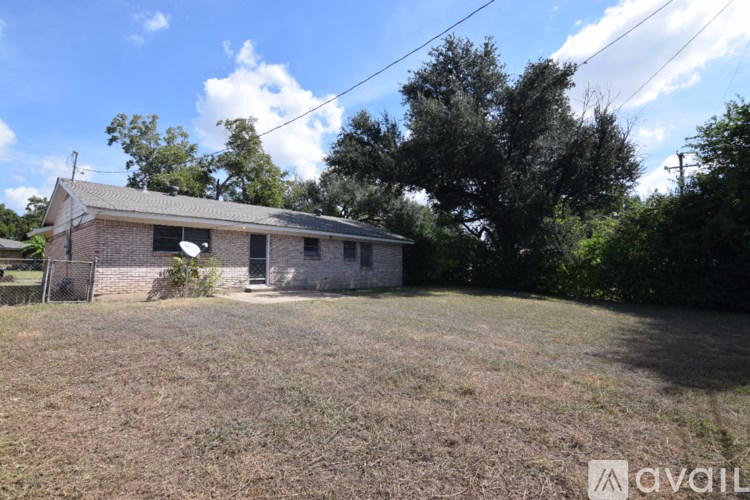 A house with a fence and trees in the background.