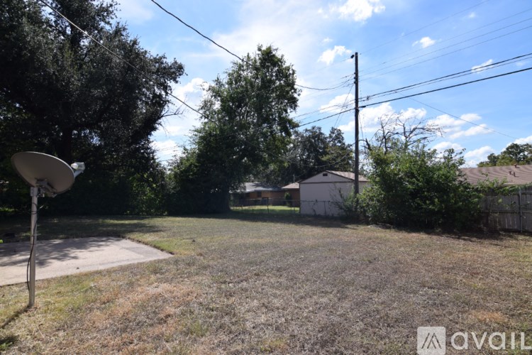 A backyard with a satellite dish and a house in the background.