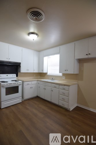 A kitchen with white cabinets and a black stove top.