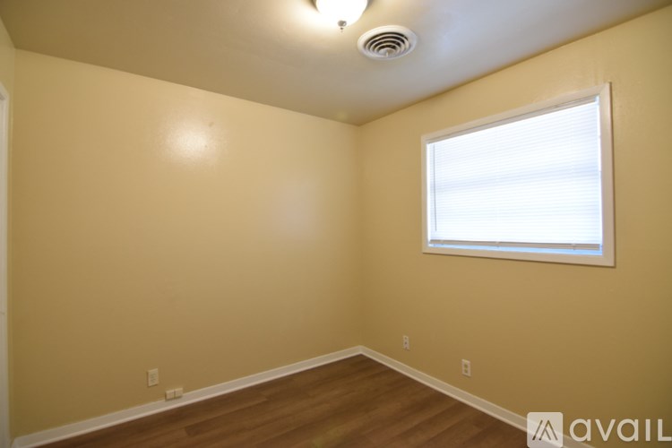 A room with a window and wooden flooring.