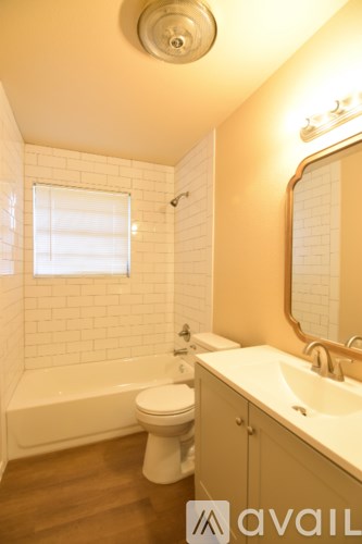 A white toilet sits next to a white sink in a bathroom.