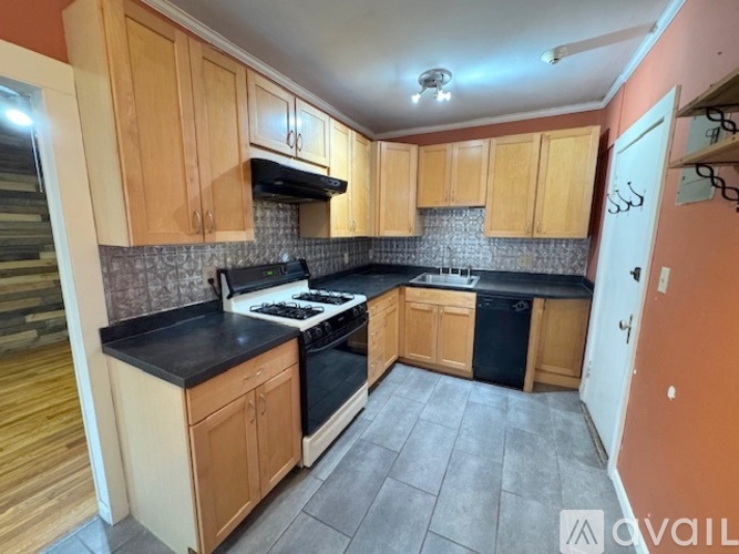 A kitchen with wooden cabinets and black countertops.