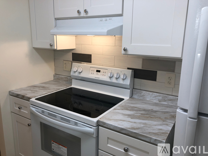 A kitchen with a white oven and a white fridge.