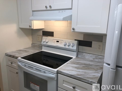 A kitchen with a white oven and a white fridge.