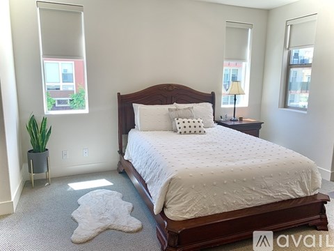 A bedroom with a large bed and a potted plant.
