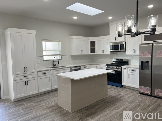 A modern kitchen with white cabinets and a central island.