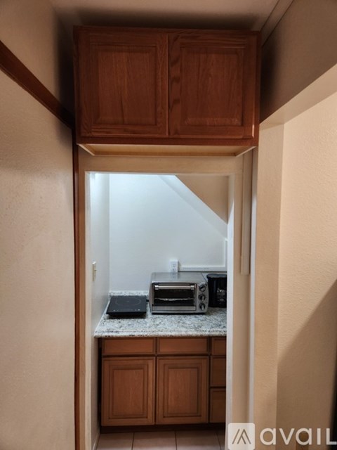 A kitchen with wooden cabinets and a microwave on a countertop.