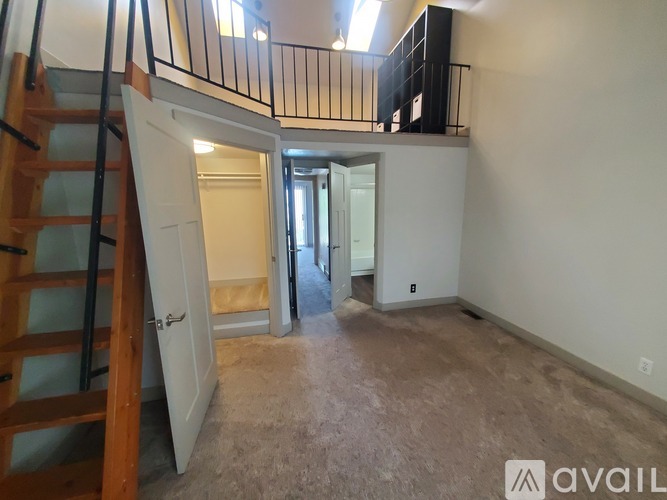 A hallway with a patterned carpet leads to a bedroom.